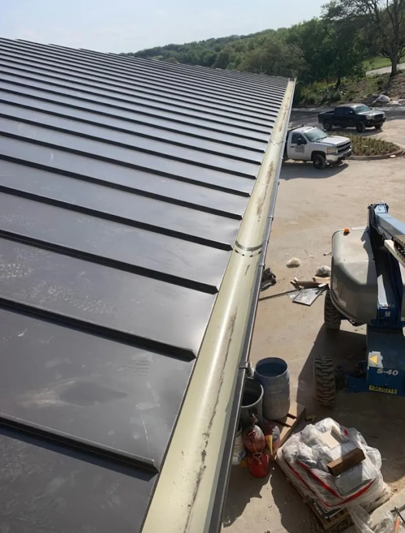 Standing seam panel and gutter detail on a metal roofing jobsite in Glen Carbon